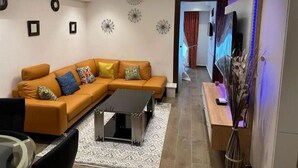 Una sala de estar moderna con un sofá modular, una mesa de centro y decoración en la pared.