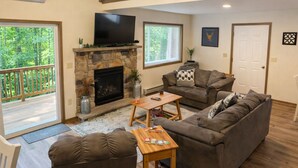 Una sala de estar con chimenea, televisor, sofá y una mesa de centro.