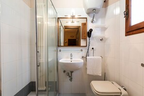 Regadera, secadora de cabello, toallas, papel de baño 