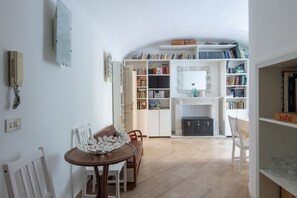 Una habitación con una mesa de comedor, sillas, una estantería y una chimenea.
