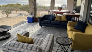 A covered outdoor seating area with stone pillars, a table, and chairs. - Amazing Views in the Luxury & Awesome house!   (B.C.S.)