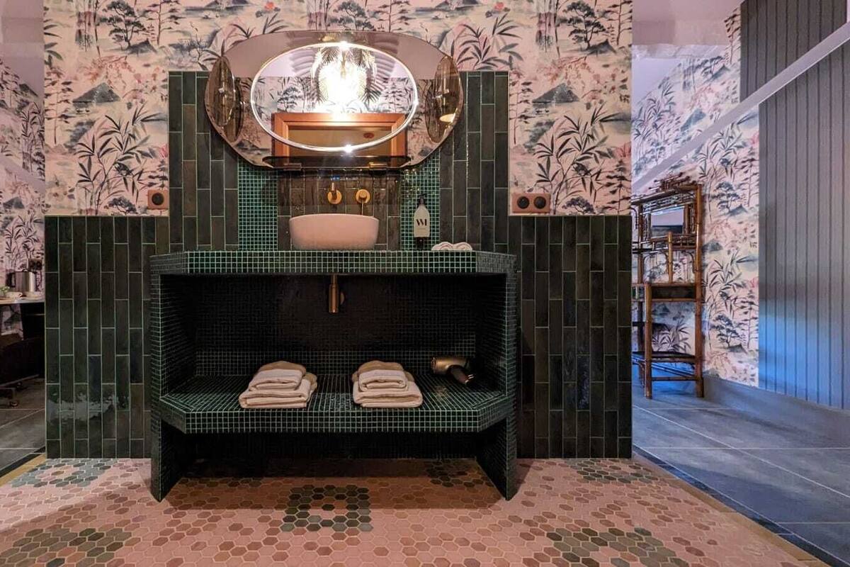 A spa area with a bench, a mirror, and a sink.