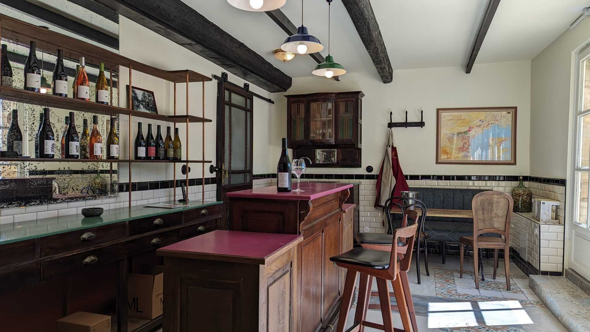 A kitchen with wooden cabinets, a bar area with bottles, and a map on the wall.