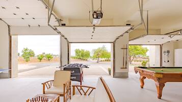 An indoor recreational area with a foosball table, pool table, and chess set.