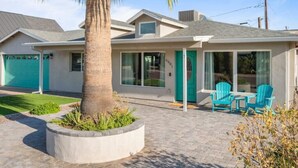 A modern house with a garage, a patio with chairs, and a palm tree. - Luxury Scottsdale Home, walk to Old Town
 (Scottsdale)