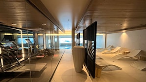 A modern hotel lobby with a treadmill, seating area, and a large vase.