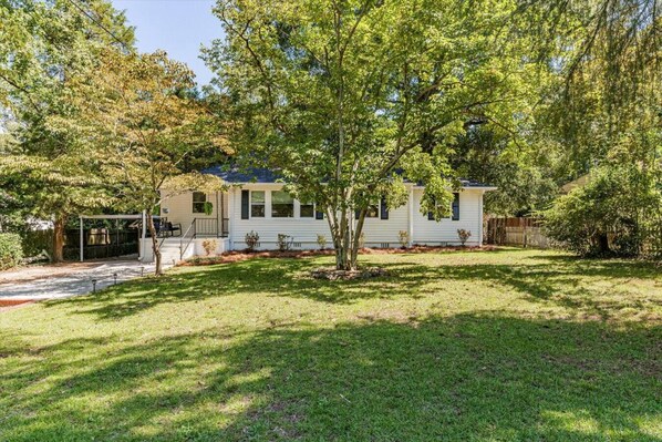 A single-story mobile home with a front porch, a small front yard, and a tree in front. - Par 4 the Bath Getaway - All New (Augusta)