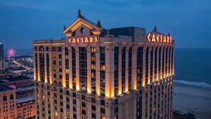 Un hotel moderno de gran altura con letreros que dicen "CAESARS", de estilo arquitectónico clásico con grandes ventanales y una entrada destacada.