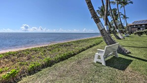 Une vue sur la plage avec un banc et des palmiers.