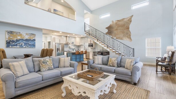 A spacious living room with two sofas, a coffee table, and a staircase leading to an upper level. - Restful Getaway with Boat Parking, Hot Tub, Free Attraction Tickets & 1 Mile to State Park Marina (Branson)