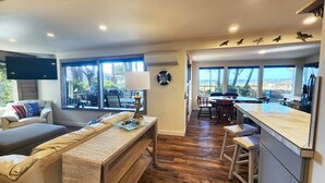 A modern living room with a sofa, a coffee table, and a dining area with a table and chairs.