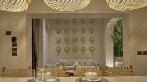 A dining area with a table set for two, featuring a clear glass pitcher and a glass on a woven placemat. - Casa Antal  -  Yucatan Home Rentals (Mérida)