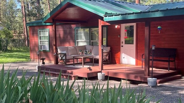 A cabin with a porch, outdoor seating, and a small deck. - Horseshoe Canyon | Cozy 3BR Cabin • Pet Friendly (Ruidoso)
