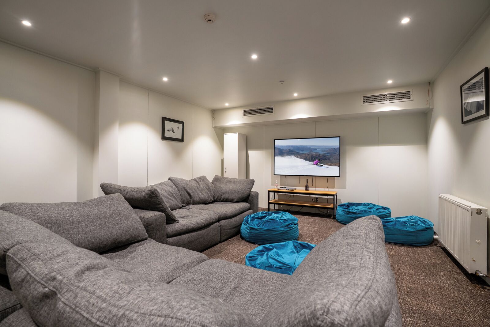A modern living room with a sectional sofa, a flat-screen TV, and a small wooden coffee table.