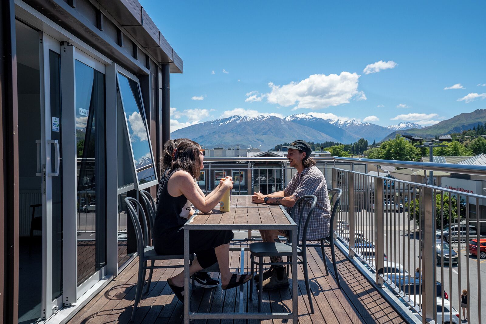 Una pareja cenando en una terraza de madera con vista a la montaña.