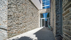 A stone building with a modern glass entrance and a bicycle parked outside. - The Brownston Hostel (Wanaka)
