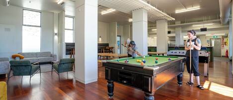 Un espace intérieur vaste et accueillant, doté d’une table de billard, de sièges confortables et d’une ambiance lumineuse et agréable.