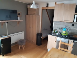 Kitchen features a dishwasher, sink, and shelf with a picture frame.