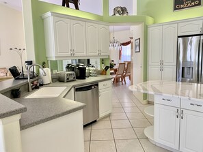Enjoy cooking in this well-lit kitchen with a view of the dining area, featuring a dishwasher, toaster, and coffee maker.