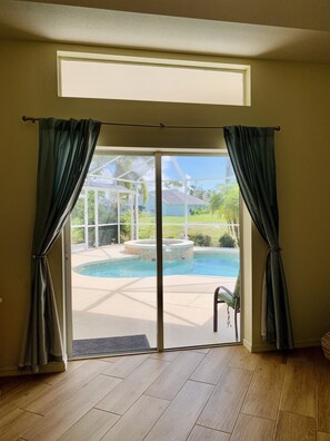 Enjoy an outdoor space with a sliding glass door leading to a pool and hot tub area.