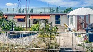 Il s’agit d’une propriété résidentielle dotée d’un jardin clôturé, d’un patio couvert et d’un numéro de maison bien visible : « JARY 31 ».