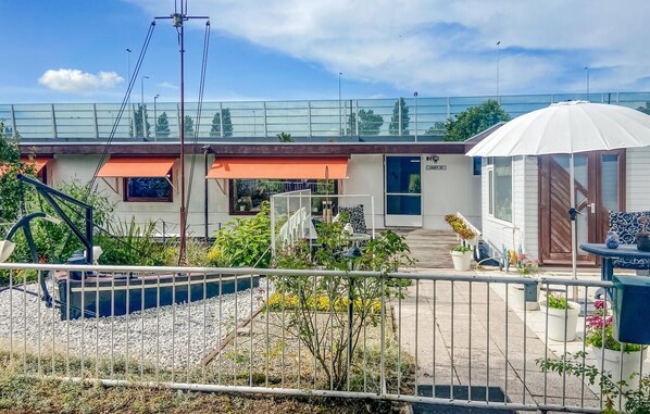 Propiedad residencial con jardín cercado, patio cubierto y número de casa visible, 'JARY 31'.