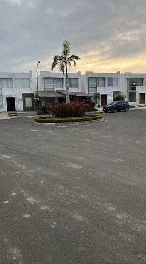 Contemporary building with parking and lush greenery.