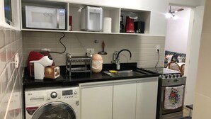 Cocina compacta con lavadora, microondas, tostadora y horno.