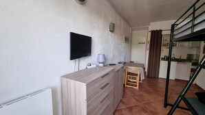 A compact living space with a kitchenette, a TV mounted on the wall, a small dining area, and a bunk bed. - 604 SKY- estudi 3 pers-balco-10 m piste- Pas de la Casa- 005778 (Pas de la Casa)