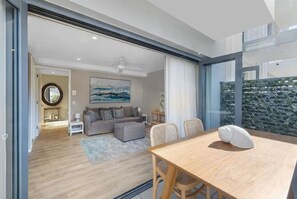 Relax in this stylish living space with a dining area, comfortable sofa, and large abstract art piece.