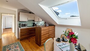 Een moderne keuken met dakraam, houten kastjes en een eethoek met een tafel en stoelen.