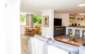 A modern apartment with a dining area, kitchen, and living room.