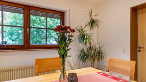 A dining table with a checkered tablecloth, a vase with flowers, and chairs.