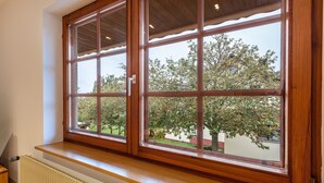 A room with a large window, a radiator below, and a wooden bench.
