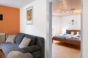 Ett rum med en soffa, en säng och ett element.
