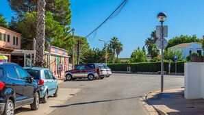 A street with parked cars, a speed limit sign, and a building with a signboard. - Apartment 'Relax' with Shared Garden, Balcony and Wi-Fi (Ciudadela de Menorca)