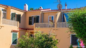 A building with balconies, a satellite dish, and a clear blue sky. - Apartment 'Relax' with Shared Garden, Balcony and Wi-Fi (Ciudadela de Menorca)