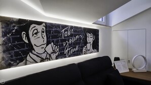 A modern room with a large wall mural, a desk with a computer, and a circular light fixture. - Italianway Comfort - Torino 48 (Milan)