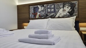 A neatly made bed with white linens and folded towels, a wooden headboard, and a wall art piece above it. - Italianway Comfort - Torino 48 (Milan)