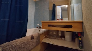 A bathroom with a bathtub, a sink, a mirror, and a towel rack. - Paradiski closed to the slopes vallandry (LANDRY)
