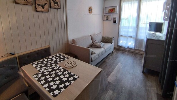 A modern living room with a sofa, a coffee table with a floral pattern, and a television. - Paradiski closed to the slopes vallandry (LANDRY)