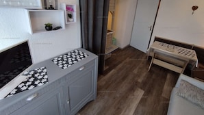 A compact living space with a kitchenette, a small seating area, and a door leading to another room. - Paradiski closed to the slopes vallandry (LANDRY)