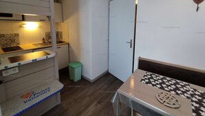 A compact kitchen with a sink, a small trash bin, and a table with a decorative item. - Paradiski closed to the slopes vallandry (LANDRY)