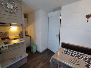 A compact kitchen with a sink, a small trash bin, and a table with a decorative item. - Paradiski closed to the slopes vallandry (LANDRY)
