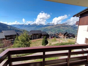 A residential area with multiple buildings, a clear sky, and mountains in the background.