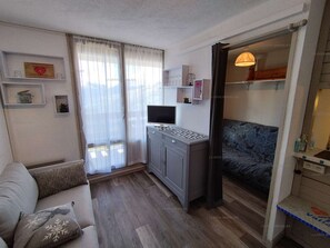 A modern living room with a grey sofa, a small cabinet, and a television. - Paradiski closed to the slopes vallandry (LANDRY)