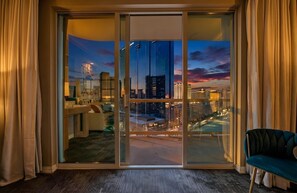 A hotel room with a large sliding glass door leading to a city view at dusk. - Studio 25 HIGH FLR MGM Signature Balcony (Las Vegas)