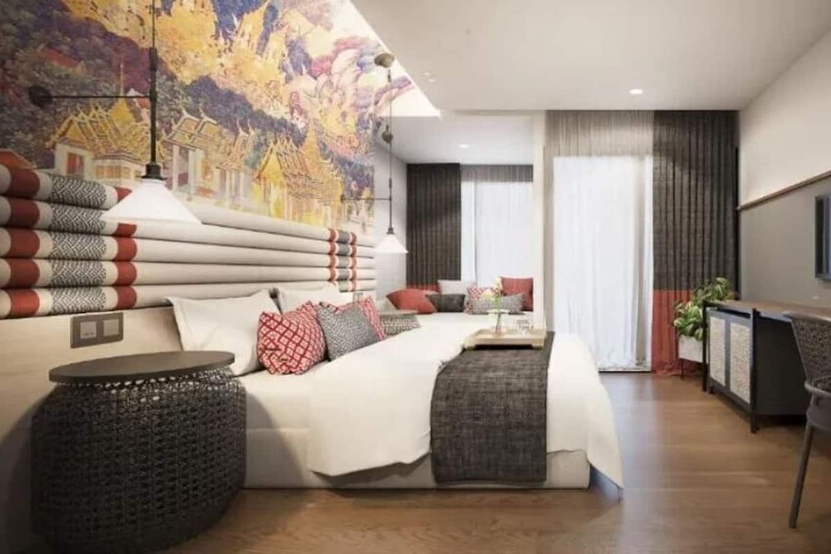 Un dormitorio moderno con una cama grande, un escritorio y una silla.