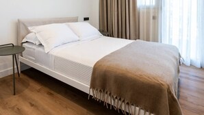 A modern bedroom with a single bed, a bedside table, and a large window with curtains. - 2-BD Luxury Apt  Sea View Balcony near the beach (Voula)