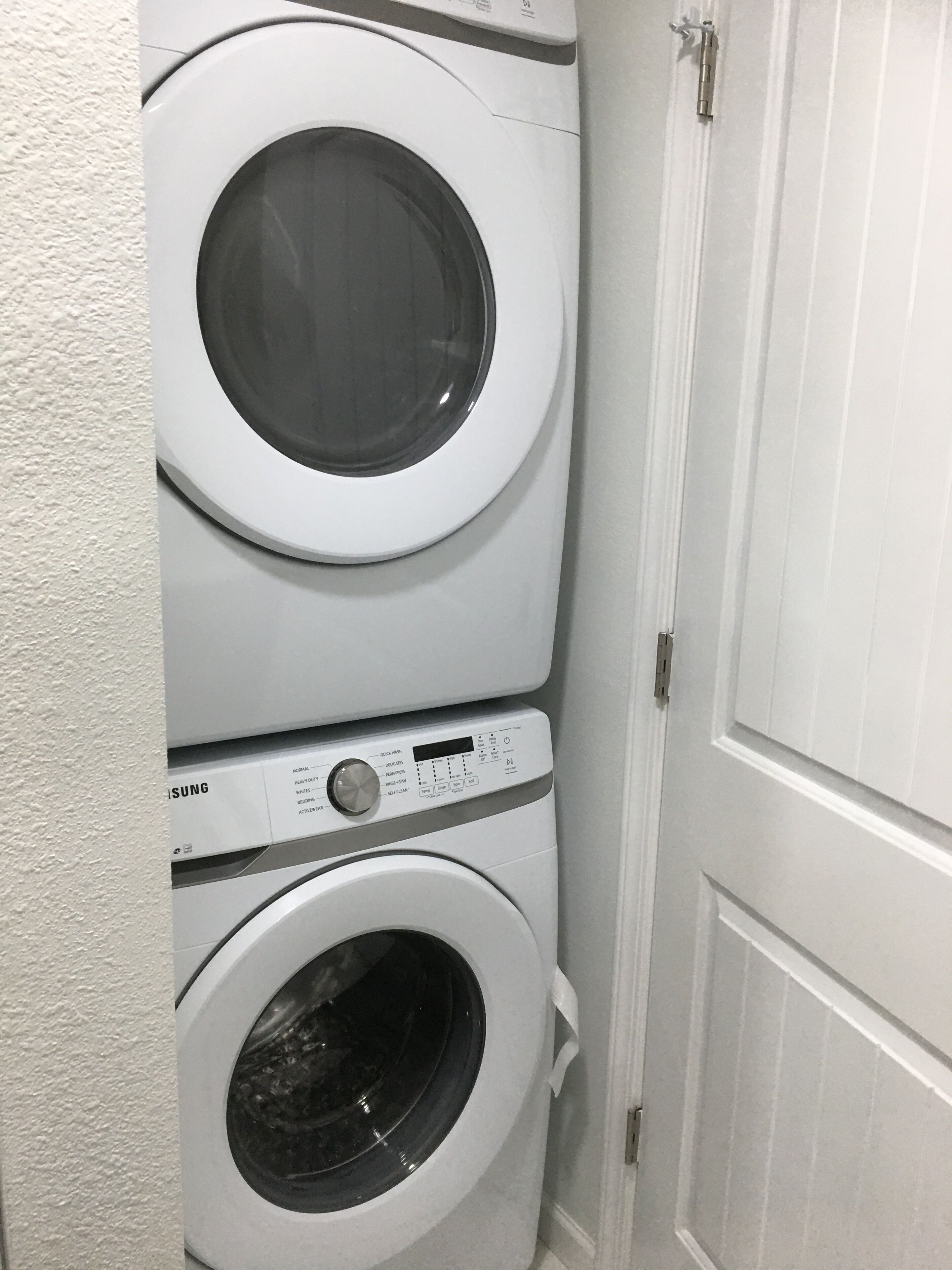 A stacked washer and dryer unit in a laundry room.